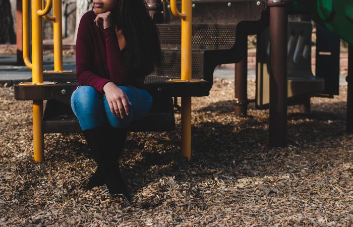 teenage African American girl sits on a playground step, representing the signs of human trafficking in schools