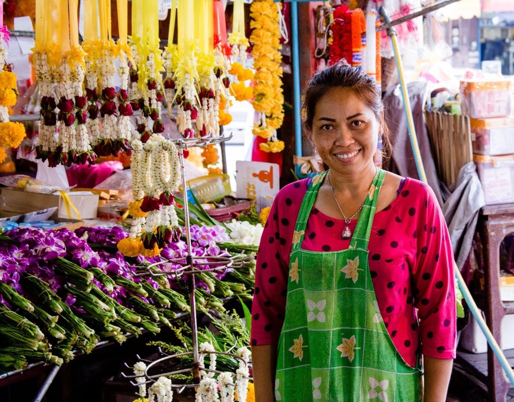 Thai woman business owner smiling and standing in her shop, representing the fair trade movement