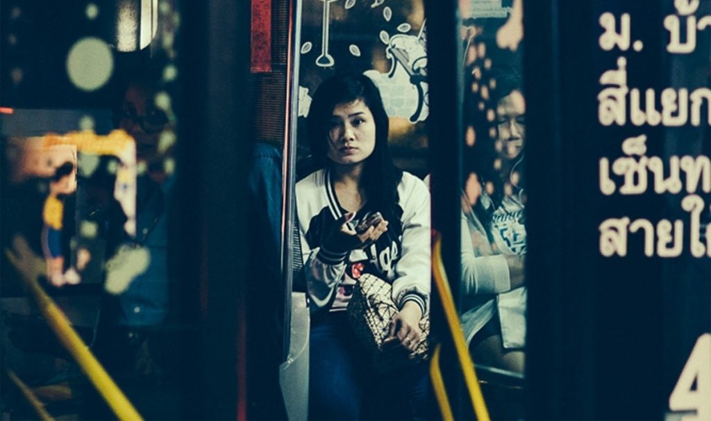 young woman standing on a street looking desperate