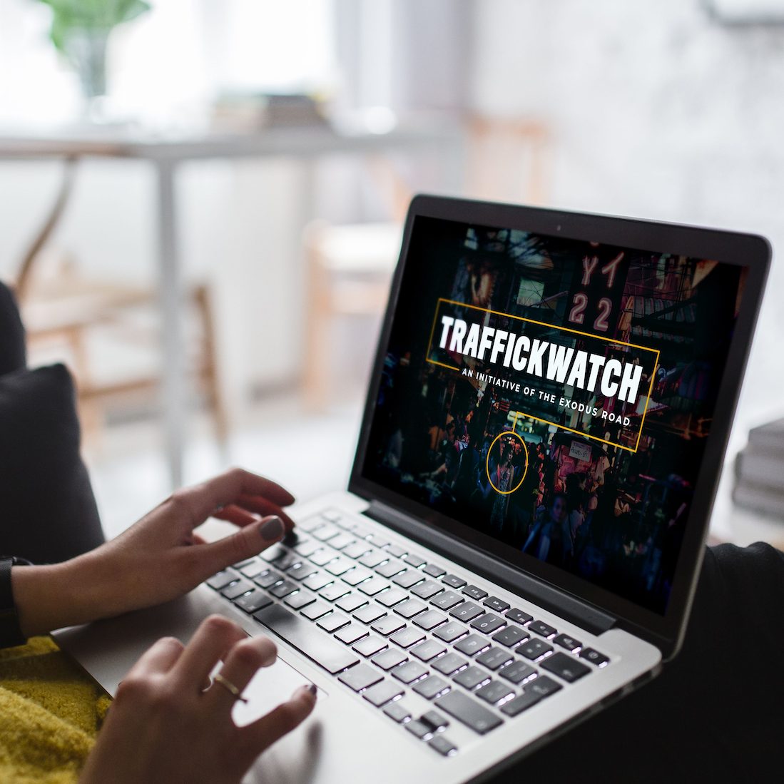 Woman navigates to TraffickWatch Academy webpage on a laptop computer.