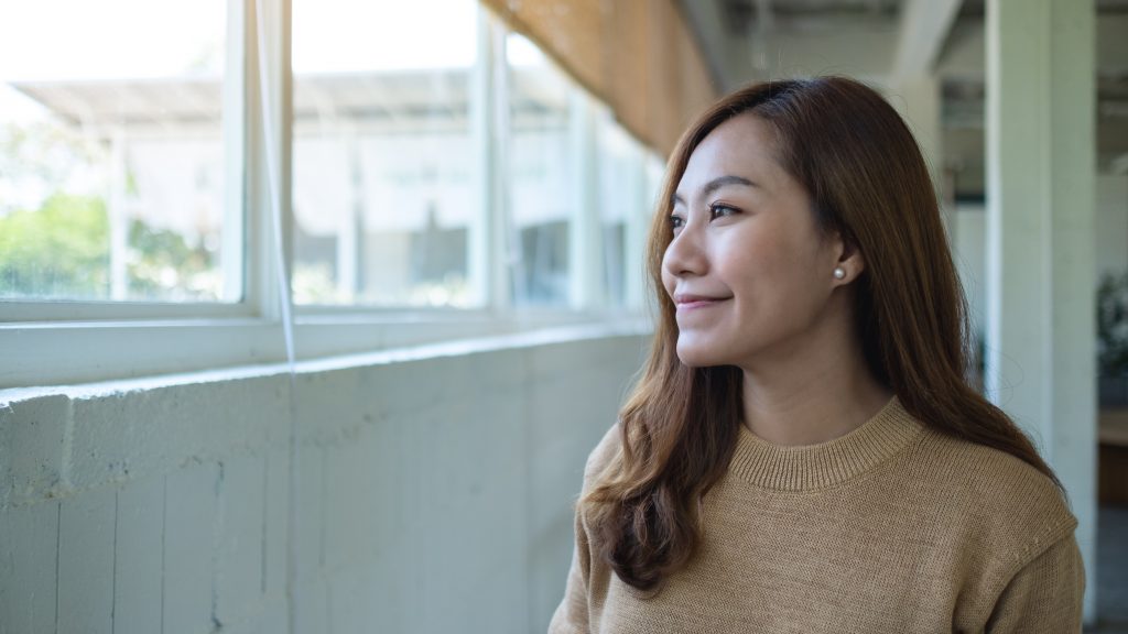 Portrait image of a beautiful young asian woman sitting in cafe.