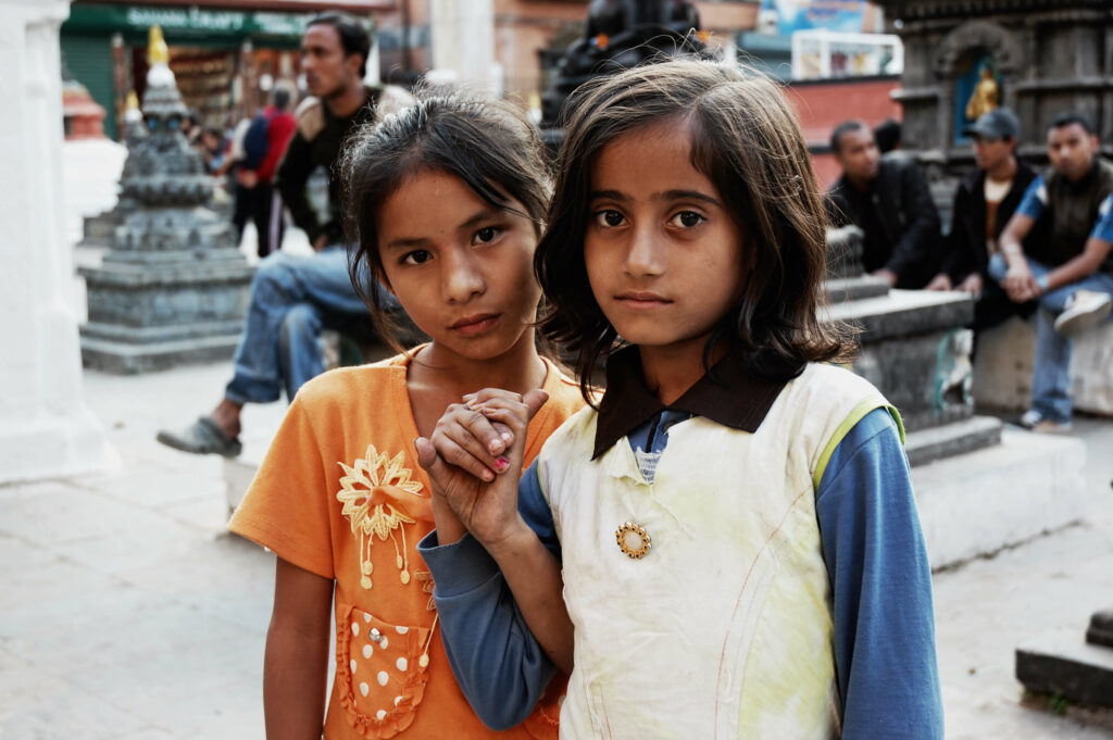two young South Asian girls looking solemnly