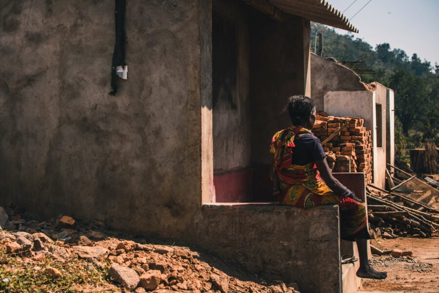 Indian woman sitting on a ledge looking out into the distance