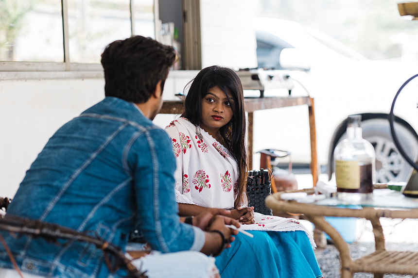 representative young Indian woman sitting with her representative trafficker, illustrating the complex psychologic bonds survivors can form with their abusers or traffickers, making it difficult for them to leave