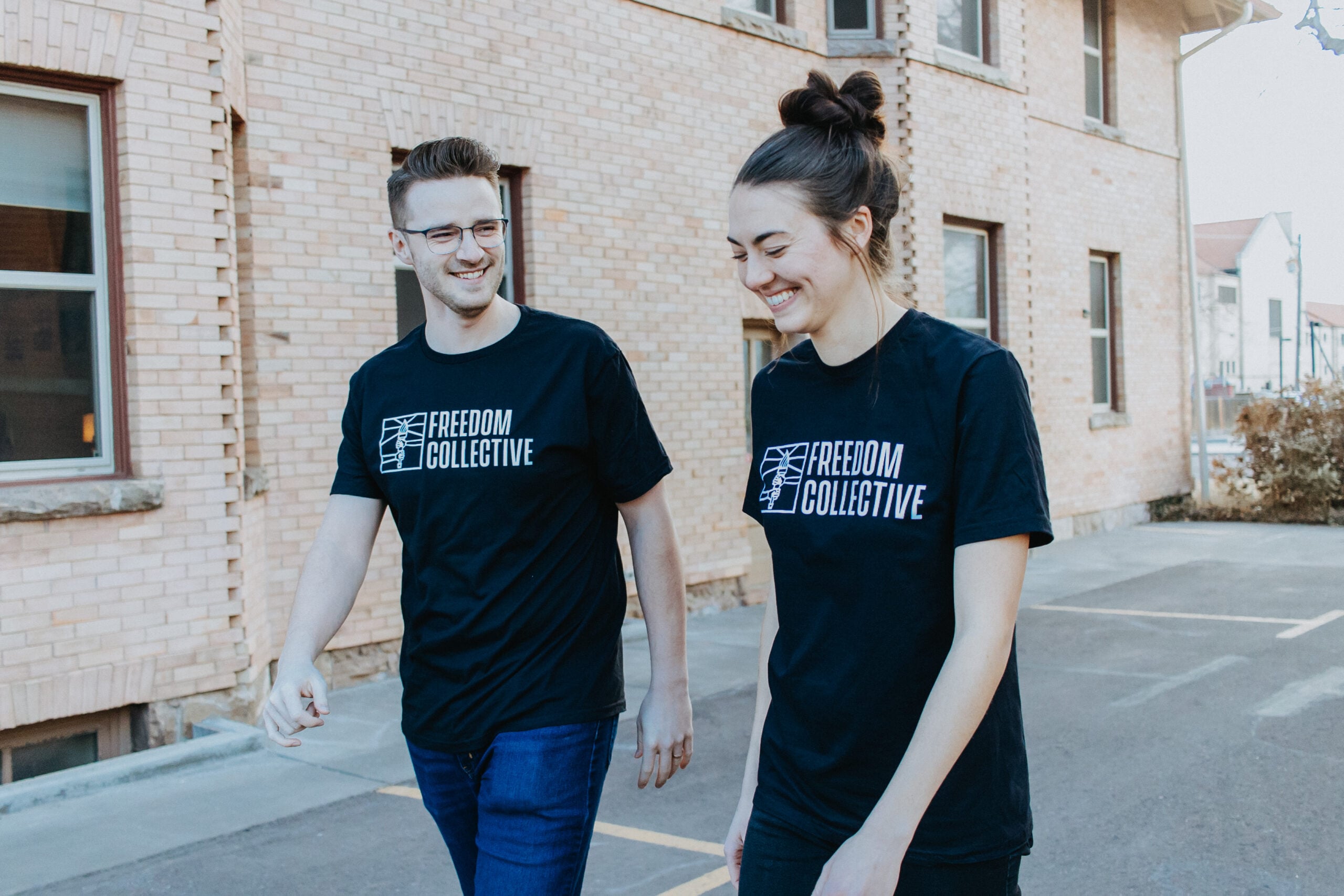 Couple walks wearing Freedom Collective t-shirts from The Exodus Road
