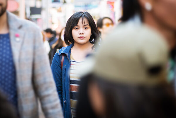 young woman standing in a crowd, representing the need for human trafficking investigation that seeks to identify victims