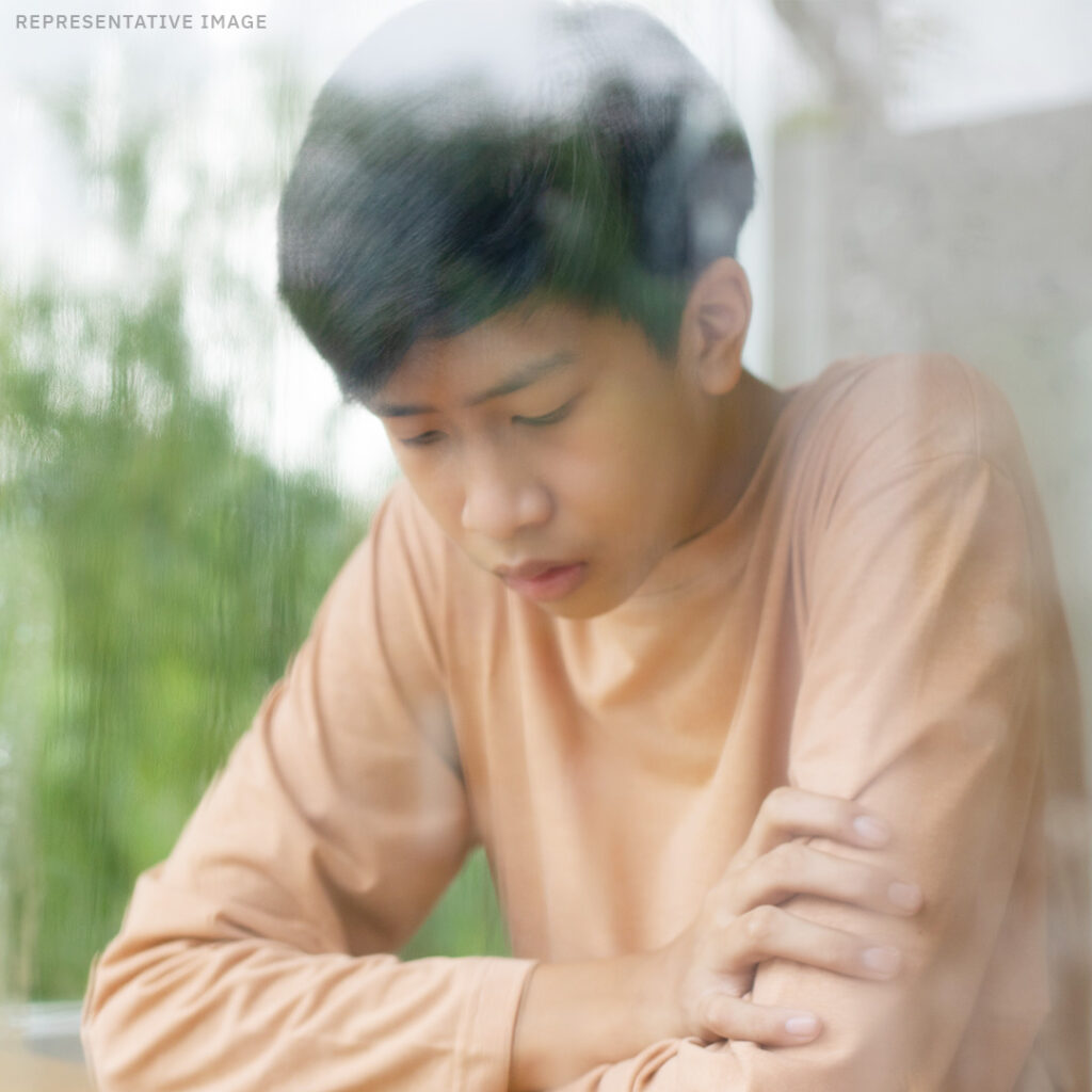 teenage Thai boy looking down