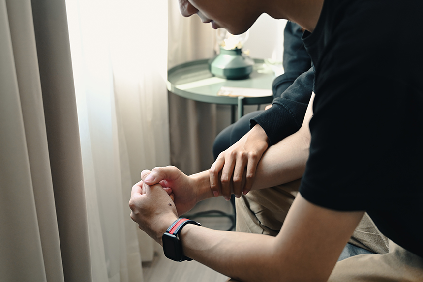 young man being comforted by a supportive person, illustrating that importance of what human trafficking social workers do