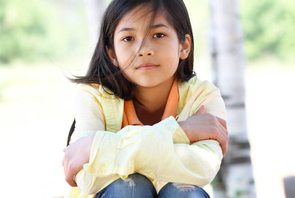 young Thai girl looks solemnly at the viewer