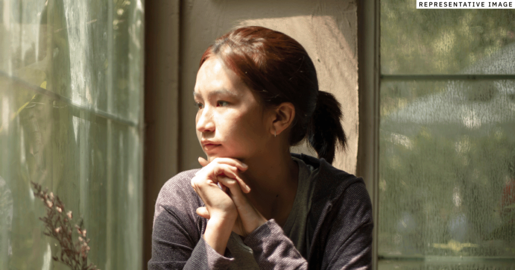 young Thai woman looking out the window