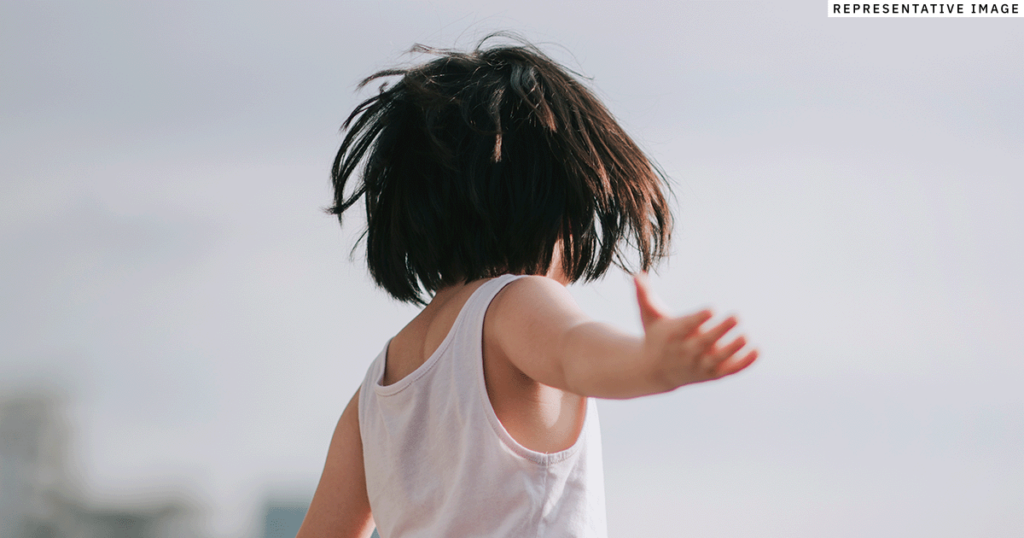 young Asian child outside looking away from the viewer
