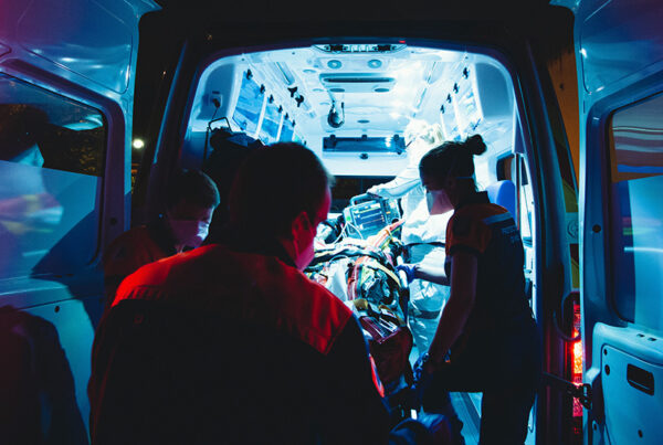 medical professionals tending to a patient in the back of an ambulance