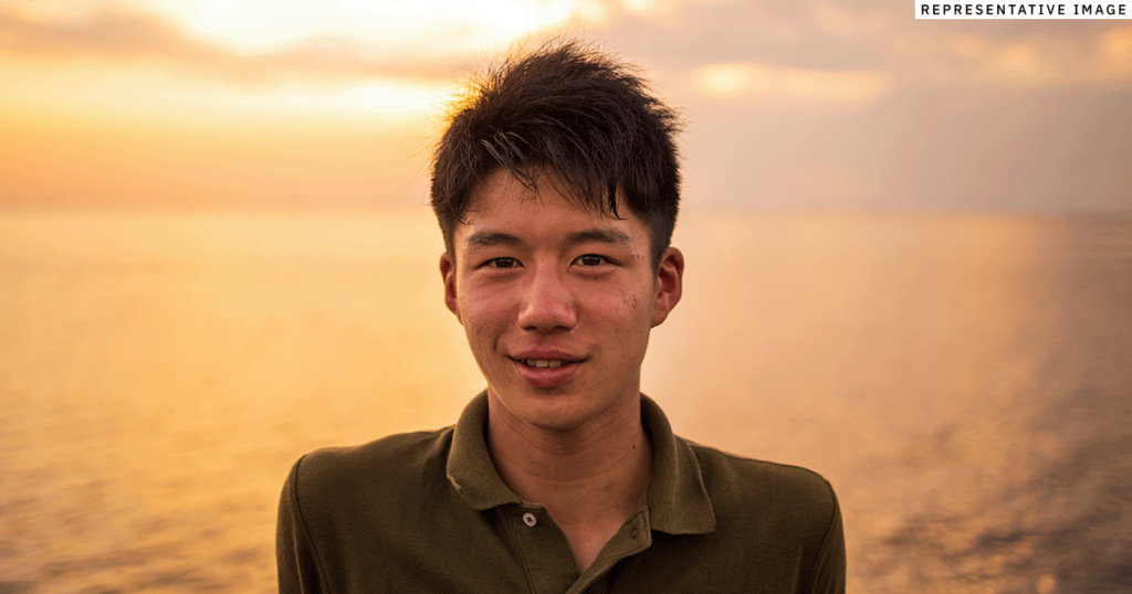 young Filipino man standing outside, smiling