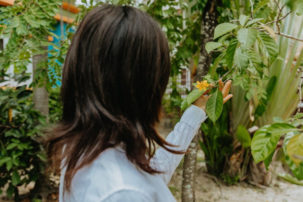 Sex trafficking survivor, Som, looking at flowers on the grounds of The Exodus Road's Freedom Home in Thailand