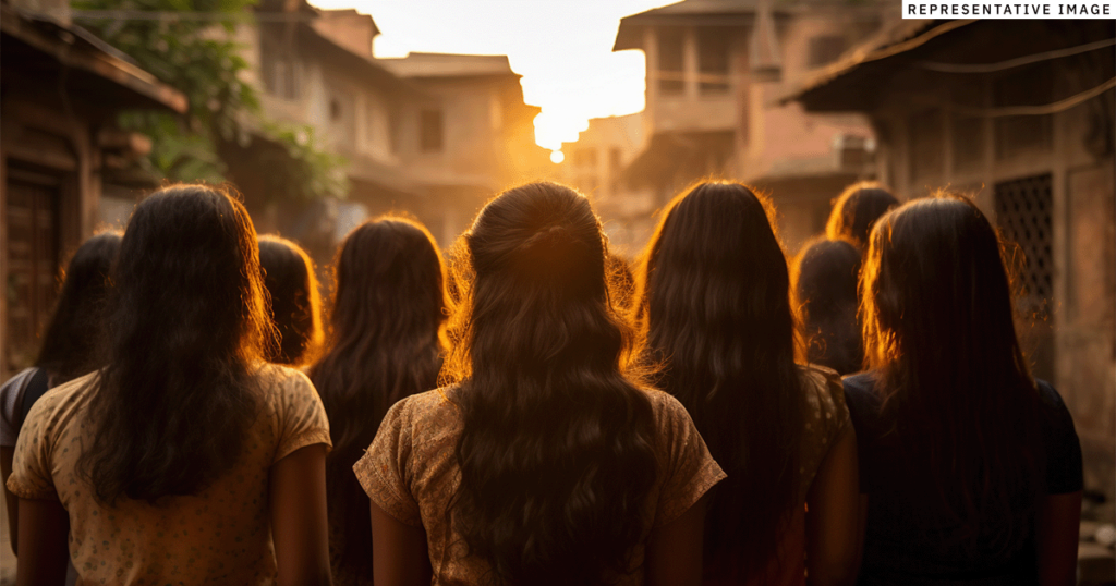 Young Indian girls standing together in a city street looking away from the camera