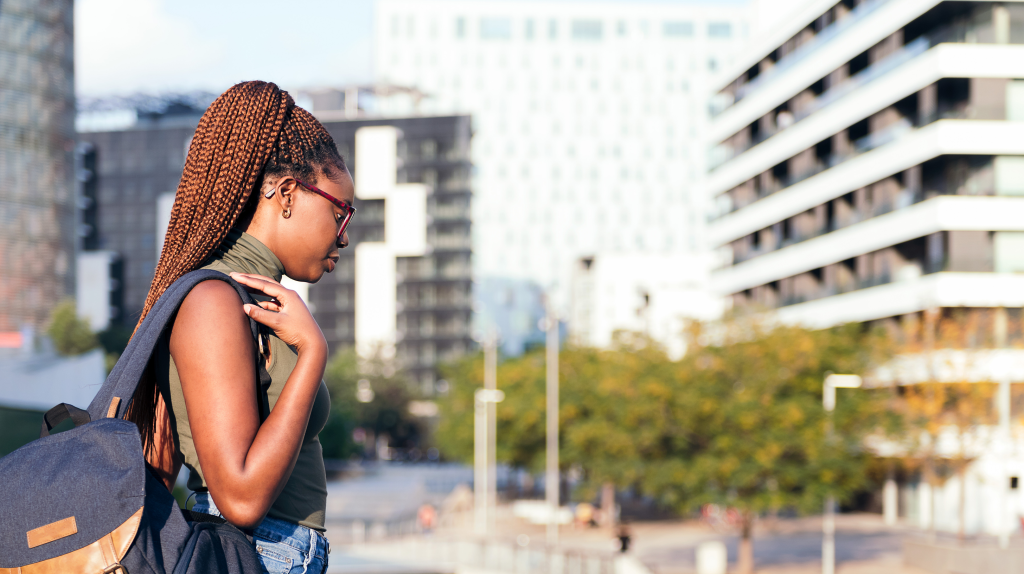 A young black woman walks through an urban area