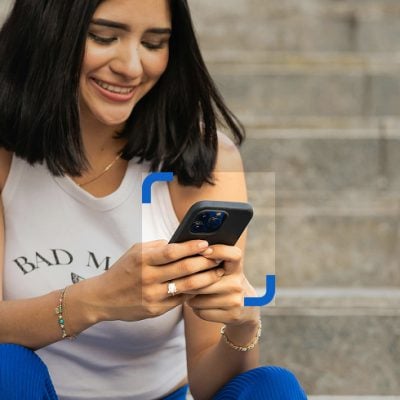 A young woman using her phone, with a box highlighting the device