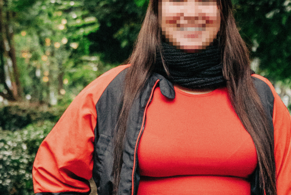 Mabelly, a survivor of sex trafficking, smiles with her face obscured for security