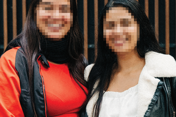 Mabelly Survivor Story 02 Mabelly, a survivor of sex trafficking, smiles alongside her sister, their faces obscured for security