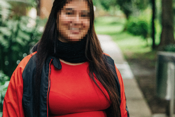 Mabelly Survivor Story 04 Mabelly, a survivor of sex trafficking, smiles with her face obscured for security