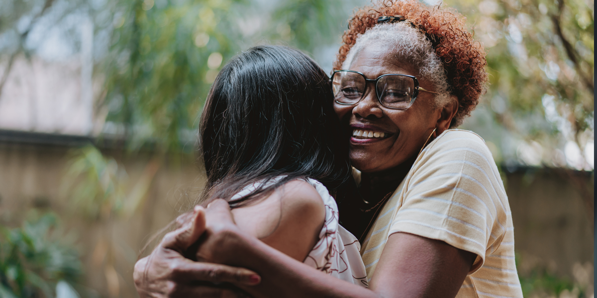 A female social worker embraces a younger woman client