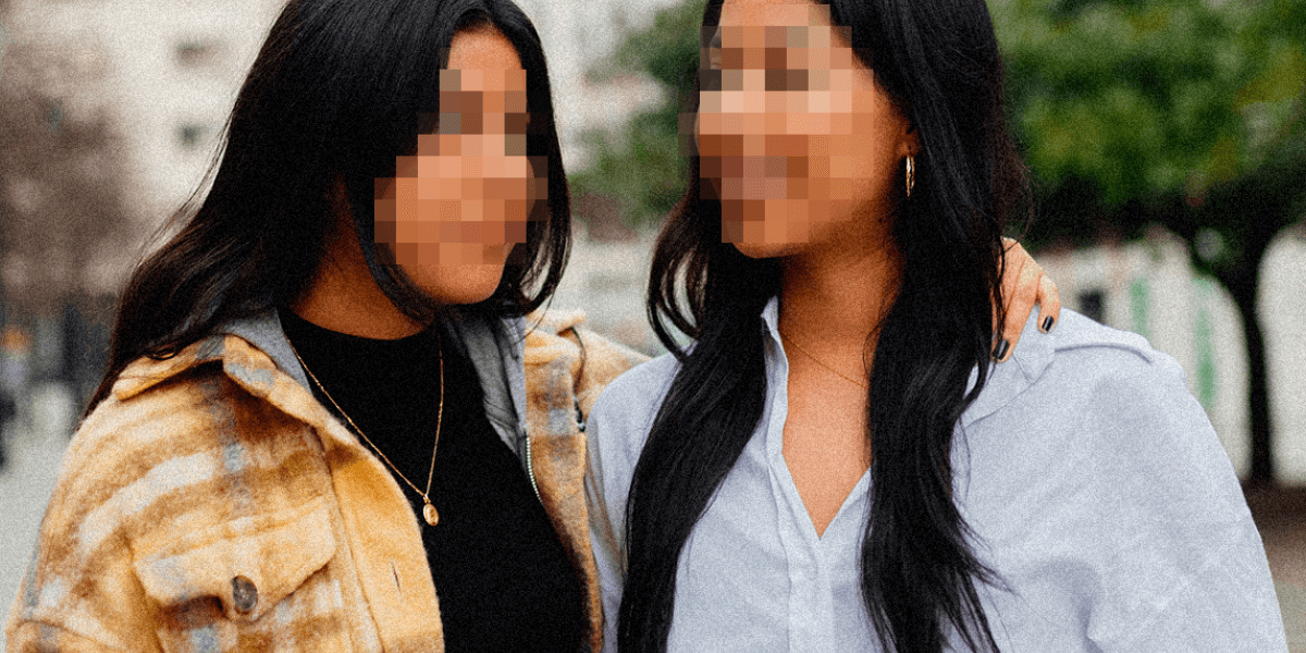 Two latina women stand together outside.