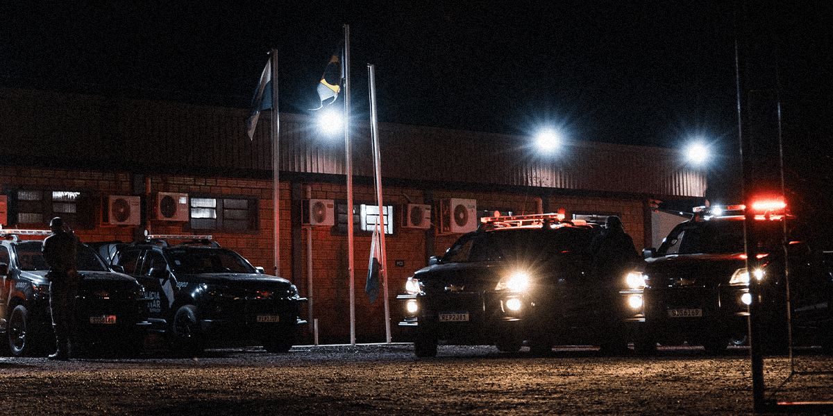 International police vehicles lined up in front of a station at night.