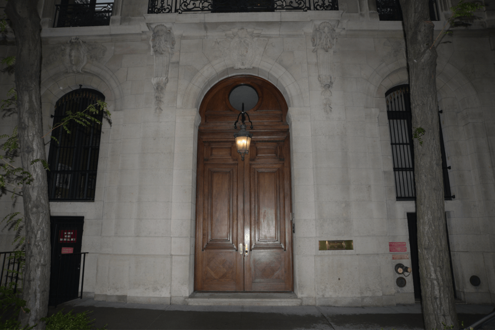 Arched wooden front doors of Jeffrey Epstein’s former Manhattan townhouse at night