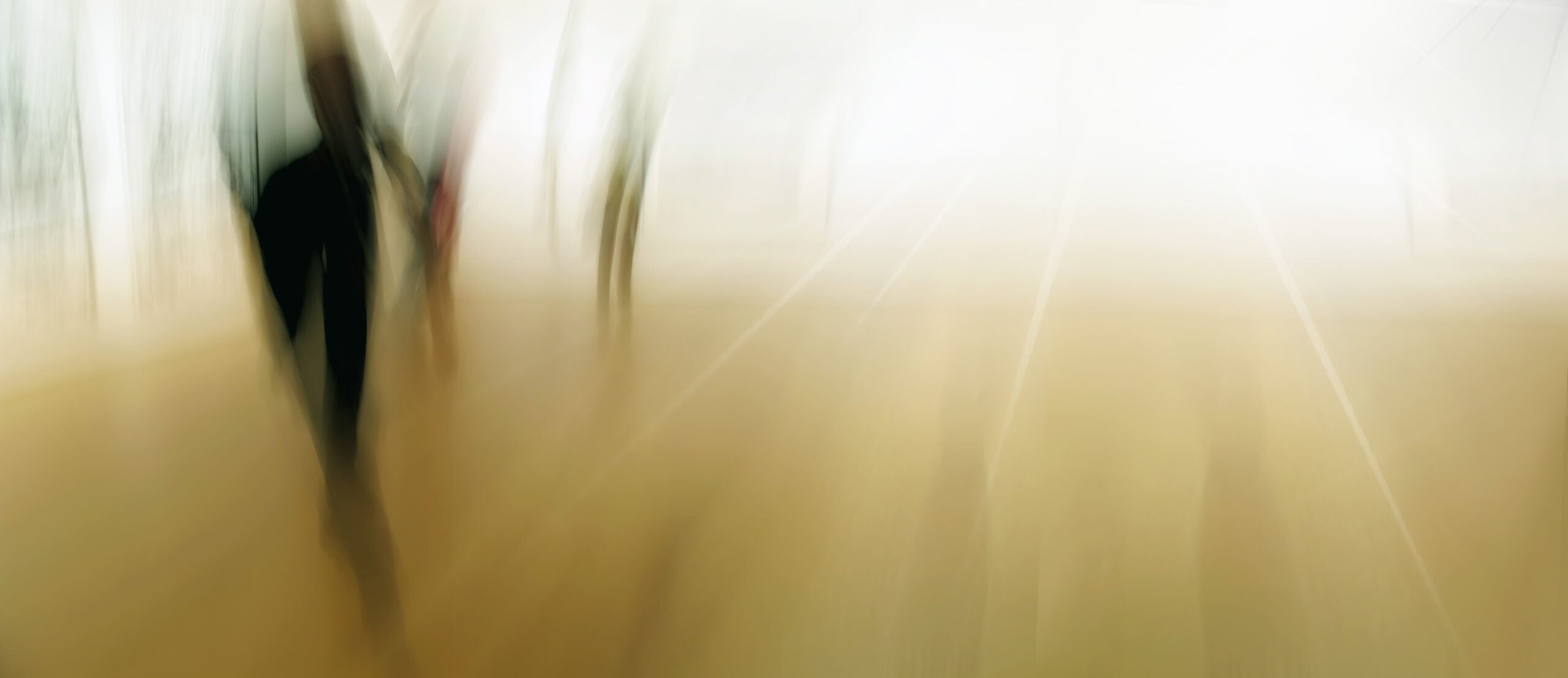 Motion blur people walking on a beige street